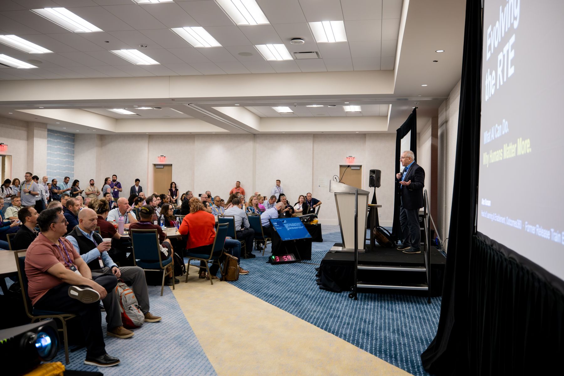 Alex Kanaan speaking to a packed room at the 2026 SAFe & AI Summit in San Diego